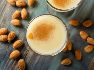 Amaretto sour cocktail top down, milk cocktail with almonds and cinnamon.