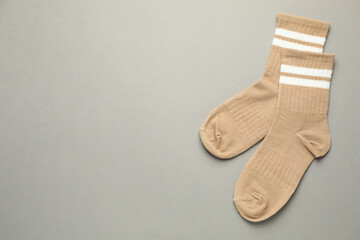 Pair of soft socks on light grey background, top view. Space for text