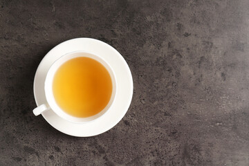 Refreshing green tea in cup on grey textured table, top view. Space for text