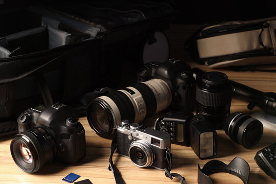 Professional photographer's equipment and backpack on wooden table