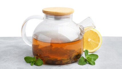 Aromatic mint tea in glass teapot, fresh leaves and lemon on light gray table against white...