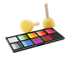 Bright face paint palette and sponges isolated on white