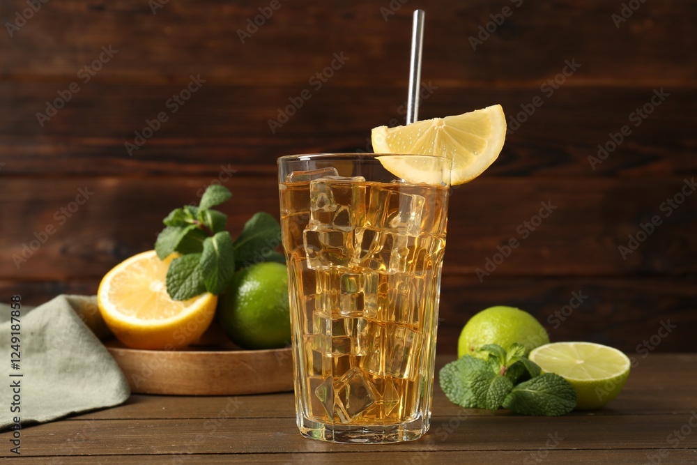 Wall mural Refreshing iced tea with slice of lemon, lime and mint on wooden table, closeup