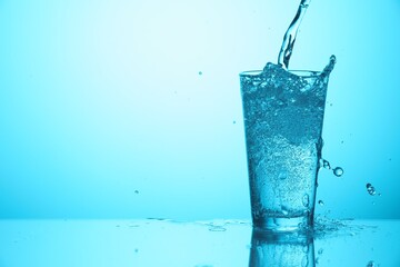 Pouring soda water into glass on light blue background, closeup. Space for text