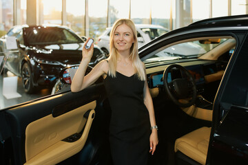 Young woman buys car from showroom and shows off keys