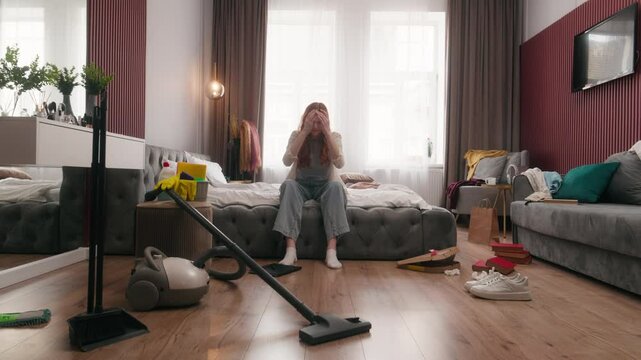 Tired stressed girl Caucasian woman female homeowner worried in bedroom mess dirt cleaning routine messy apartment frustrated housemaid housewife at home headache housecleaning problem laundry cleanup