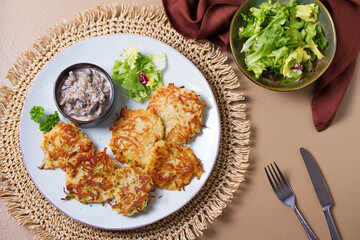 Hash browns with creamy mushrooms. Potato cakes or vegetable fritters, patties. View from above,...