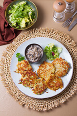 Hash browns with creamy mushrooms. Potato cakes or vegetable fritters, patties. View from above,...
