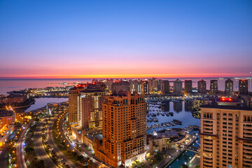 Fototapeta premium Doha, Qatar - December 20, 2024: Aerial view of Peral Qatar Porto Arabia with Doha Skyline early morning.