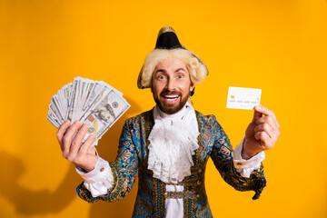 Man Dressed in Historical Costume With Money and Card Against Yellow Background