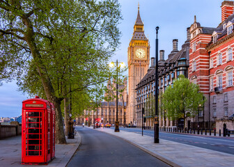 Red telephone boxes on Victoria embankment and Big Ben tower, London, UK