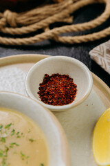 Creamy lentil soup with flatbread, sesame seeds, chili flakes, and lemon, served in an elegant style