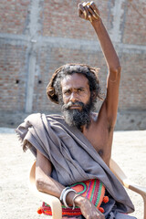 indian hindu sage with raised left hand in spiritual practice since years at outdoor at day