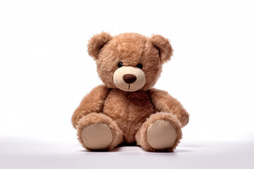Fototapeta premium Teddy bear is sitting on a white background. The bear is brown and fluffy, and it is looking at the camera. Concept of warmth and comfort