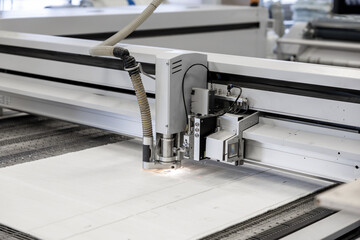 A high-tech CNC fabric cutting machine precisely cuts textile materials with automation. The advanced technology ensures accuracy and efficiency in industrial manufacturing and mass production