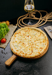 Gourmet pear and blue cheese pizza with pine nuts on wooden board in stylish restaurant setting