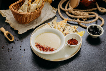 Creamy lentil soup with flatbread, sesame seeds, chili flakes, and lemon, served in an elegant style