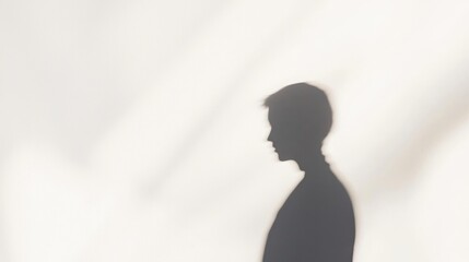 Shadow silhouette of a person against a soft, blurred background highlighting depth and minimalism in creative art photography