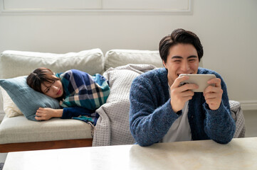パートナーが体調不良なのに看病をしないでスマホに夢中な日本人男性
