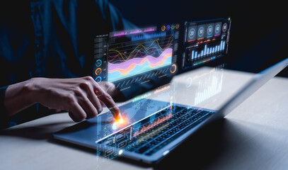 A person interacts with a laptop displaying digital graphs and data visualizations, indicating analysis or data processing in a tech-savvy environment.