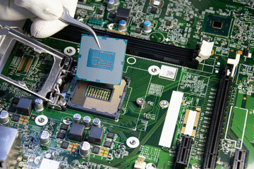 The technician is installing the CPU onto the motherboard.