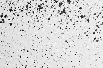gray background, photograph of black paint splashes on white wall
