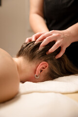 Head massage therapy with hands gently massaging the scalp of a relaxed patient. Spa and wellness...
