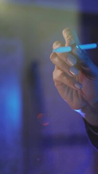 A hand holds a blue pen in a dimly lit setting, adding depth and enhancing creativity