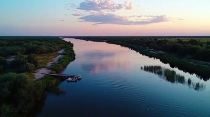 Serene sunset over a tranquil river with lush greenery and reflections in the water