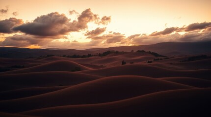 Naklejka premium Rolling Hill Landscape at Sunset with Warm Light and Cloudy Sky