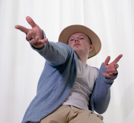 Young guy dancer in motion in a pose. A man performs a modern dance in casual clothes.