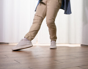 Young guy dancer in motion in a pose. A man performs a modern dance in casual clothes.