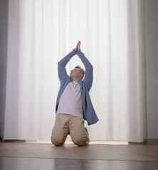 Young guy dancer in motion in a pose. A man performs a modern dance in casual clothes.