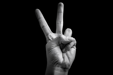 Generated image of a hand making a peace sign with two fingers raised against a black background, symbolizing peace, victory, freedom, and positive expression.