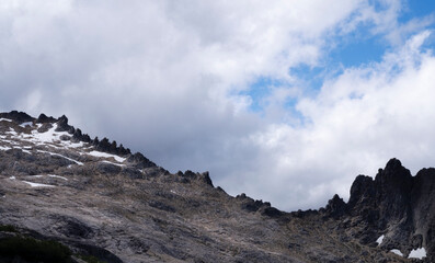 High in the cordillera. Panorama view of the rocky mountain under a magical sky with dramatic clouds