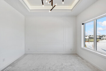 A large, empty room with a white wall and a window