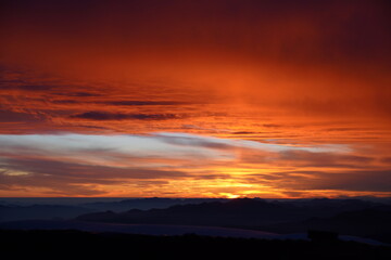 sunset illuminating the sky over the mountain range