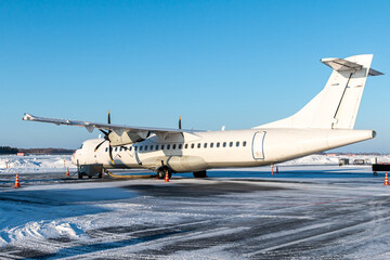 White passenger turboprop aircraft on the winter airport