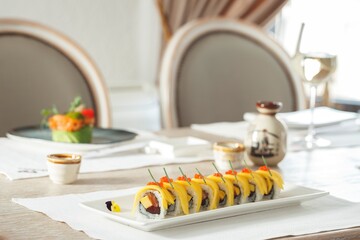 Savor exquisite sushi rolls, adorned with vibrant mango and delicate sauces, in an elegant...