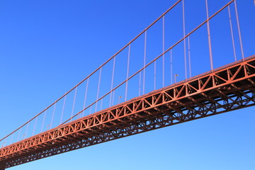 Golden Gate Bridge Close-Up with Steel Framework Against a Clear Blue Sky