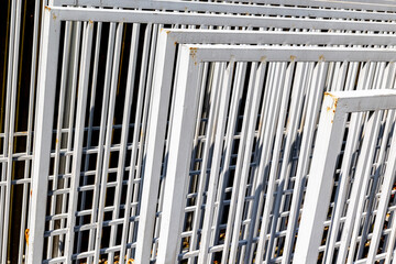 Fototapeta premium Stacked metal fences with rusty accents in sunlight