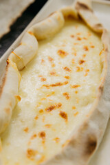Turkish cheese pide with melted mozzarella on a plate in elegant and traditional food presentation