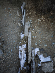 Weathered stone wall revealing snowy terrain in rugged aosta landscape, winter's quiet embrace marking italian mountainside Lillaz