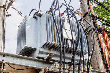 Electrical power transformer with wires on utility pole outdoors