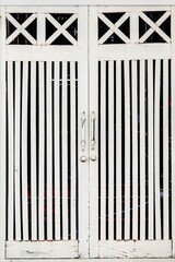 White wooden double doors with lattice design and vertical slats