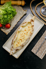 Turkish cheese pide with melted mozzarella on a plate in elegant and traditional food presentation