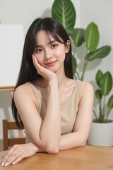 Naklejka premium Asian woman in beige, voluminous black hair, sitting gracefully at a table