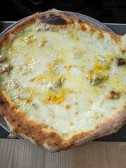 Crispy golden pizza with melted cheese, revealing authentic italian baking tradition from aosta, highlighting rustic culinary craftsmanship