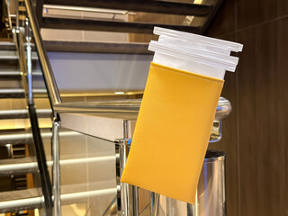 Sick bags in a container attached to a stairail for use by passengers on a cruise ship