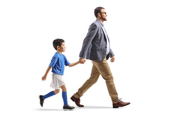 Father walking with a boy to a football training